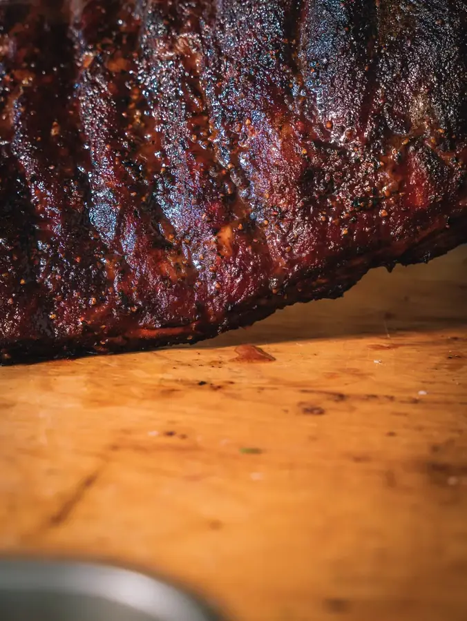 Crosta scura di un brisket affumicato sul tagliere